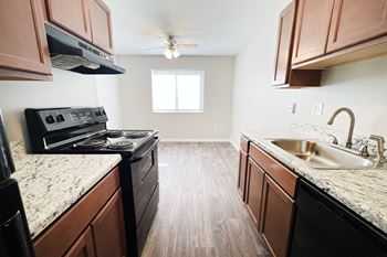 A kitchen with wooden cabinets and a black stove top oven.